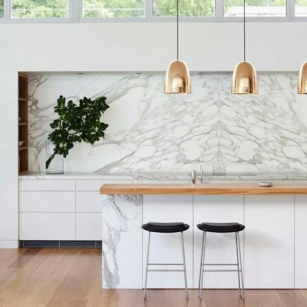 marble kitchen with brass pendant lights